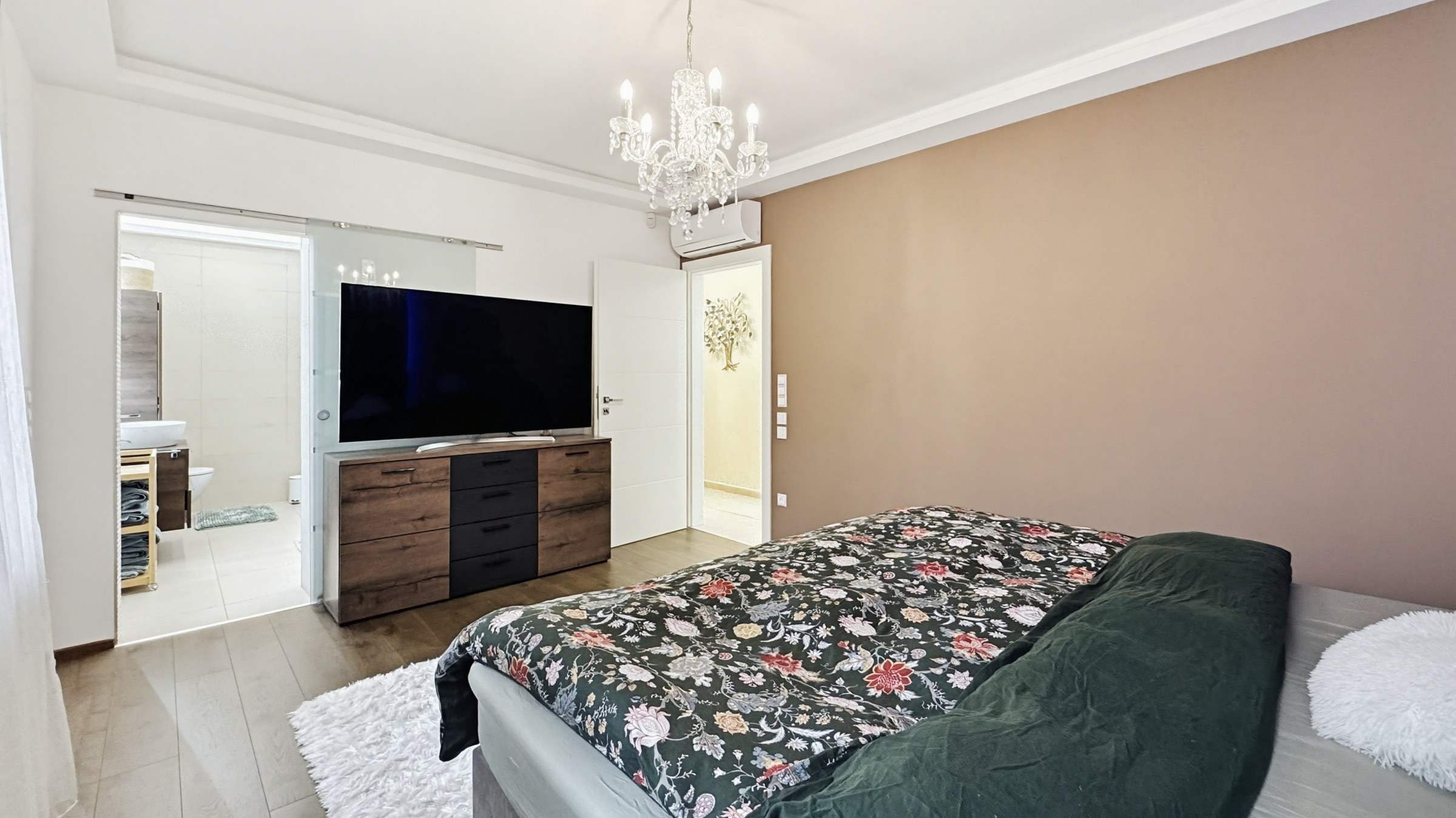 Ez egy modern hálószoba egy nagy franciaággyal, televízióval és beépített TV-szekrénnyel. Egy tolóajtón keresztül látható a fürdőszoba is. A szoba világos és jó állapotban van.